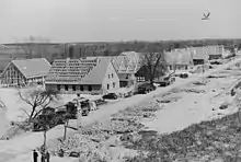 Photographie en noir et blanc du chantier d'un lotissement de larges maisons.