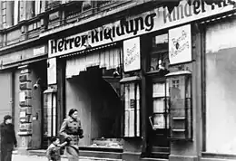 Photographie en noir et blanc de la vitrine d'un magasin juif saccagé à Magdebourg