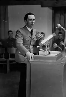 Photographie en noir et blanc de Joseph Goebbels, prenant la parole debout derrière un pupitre, en 1937