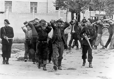Photographie en noir et blanc de miliciens effectuant une rafle, juillet 1944