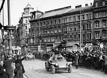 Photographie en noir et blanc montrant l'arrivée de deux unités blindées allemandes dans les rues de Vienne.