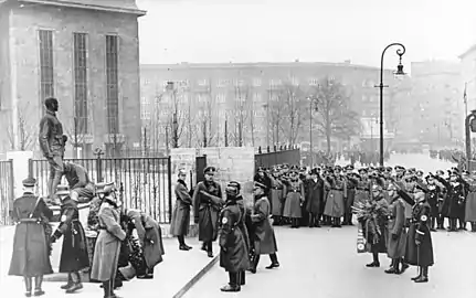 Cérémonie au pied de la statue de Wessel, le 16 janvier 1937 à Berlin. Himmler (debout à droite) fait le salut hitlérien, Heydrich (incliné devant la statue) et Daluege (de dos à gauche) déposent chacun une gerbe.