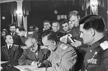 Photo noir et blanc d'un groupe d'officiers derrière une table, dont quatre assis au premier rang.