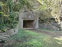 Entrée en béton d'un bunker dans une colline.
