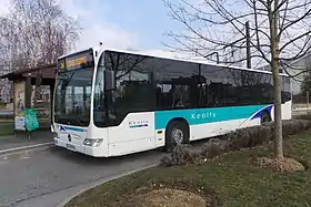 Vue d'un autobus urbain, livrée blanche et marquages bleu et vert.