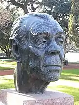 photo d'un buste : la tête d'homme aux traits marqués, observe au loin