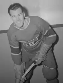 Photographie en noir et blanc d'Émile Bouchard habillé avec l'uniforme des Canadiens de Montréal et en train de poser pour la photographie.