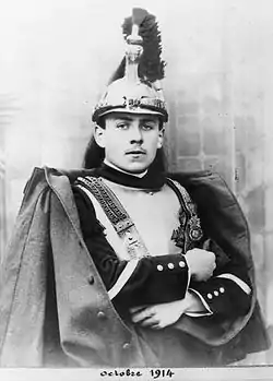 Photo en noir et blanc représentant un portrait d'un soldat portant casque, cuirasse et manteau.