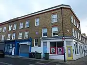 Exterior of two storey brick building with shop space on ground floor