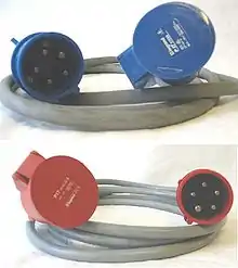 Deux câbles avec chacun une prise 3P+N+T à une extrémité et un socle de même type à l'autre extrémité. Le câble de dessus a des connecteurs bleus, celui de dessous a des connecteurs rouges.
