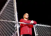 CM Punk posant devant un ring surplombé d'une cage