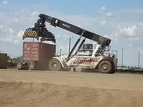 Chariot porte-conteneurs chargeant un conteneur d'un train sur un camion