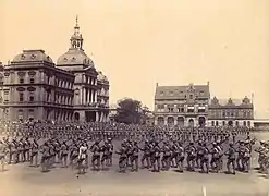 Place de l'église en 1899, parade des commandos boers devant le Raadsaal.