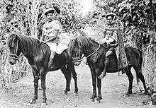 Deux cavaliers sur les chevaux, vus de profil.