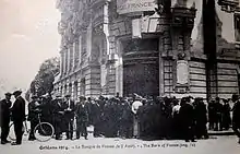 Carte postale noir et blanc montrant une file d'attente devant la Banque de France d'Orléans, le 2 août 1914.