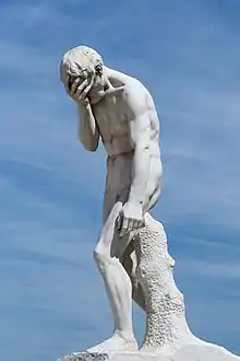 photographie d'une statue représentant un homme nu se couvrant le visage avec sa main.