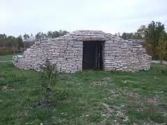 Cabane en pierre sèche moderne édifiée sur le rond-point de l'entrée de l'aéroport de Brive-Vallée de la Dordogne.