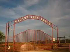 Un portail d'accès à une propriété surmonté de l'inscription Cactus Jack Ranch.