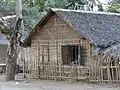 Maison en cadjan (en), nattes tressées de feuilles de cocotier. Birmanie.