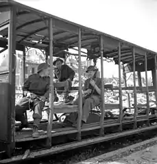 Soldats d'infanterie canadiens se reposant dans une baladeuse en juillet 1944.