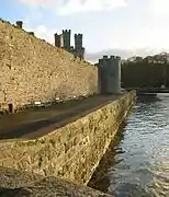 Vue d'un mur de pierre rectiligne surplombant un quai.