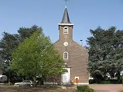 Édifice religieux en brique avec des arbres.