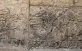 Des soldats assyriens empilent du butin et les têtes d'ennemis vaincus, en présence de scribes qui procèdent au décompte.
