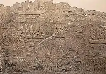 Combats dans les marécages : des soldats assyriens, sur des bateaux, débusquent des fuyards des ennemis vaincus, certains essayant de se cacher au milieu des roseaux.