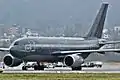 Photo d'un avion au fuselage gris bleu sur une piste.