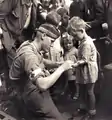 Le soldat canadien MacDonald donne les premiers soins à un enfant