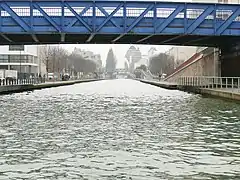 Le canal de l'Ourcq à Pantin. Au fond, la silhouette des Grands Moulins de Pantin.