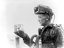 Un mineur avec une petite cage contenant un canari utilisé pour tester le gaz de monoxyde de carbone en 1928.