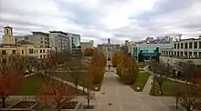 Phot d'un jardin entouré de bâtiments, avec une église en arrière-plan.