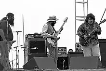 Photo en noir et blanc de trois musiciens sur scène