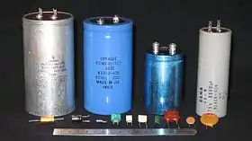 Des condensateurs de diverses capacités (au deuxième plan, 5 000 µF, 81 000 µF, 6 500 µF et 8 000 µF, devant des condensateurs de moindre capacité).
