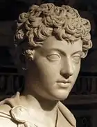 Tête de la statue d'un jeune garçon aux cheveux frisés.