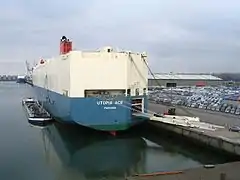 Le roulier Utopia Ace (200 × 32 m) faisant le plein de carburant (grâce à la péniche à couple) et de véhicules au Londenhaven.