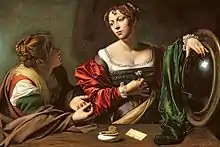 Deux jeunes femmes se parlent, un grand miroir est posé sur la table près d'elles.