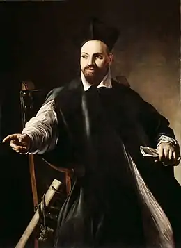 peinture d'un homme barbu en costume et toque noirs, assis dans un fauteuil et pointant du doigt vers sa droite.