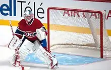 Photographie d'un gardien de but de hockey avec un maillot rouge