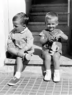 Carles Puigdemont et son frère, enfants, assis sur des marches.