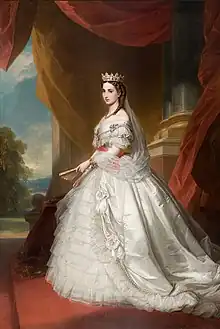 Portrait en pied, peinture à l'huile représentant Charlotte en robe de cour de couleur blanche , elle porte une couronne sur un voile qui descend jusqu'à la taille, dans sa main elle tient un éventail. À l'arrière-plan, de lourdes draperies rouges masquent un paysage arboré