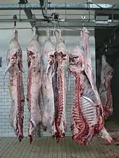 Photo de carcasses d'animaux suspendus à des crochets