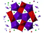 Structure de la carnotite déshydratée, projetée sur le plan (a, b). Violet : U, rouge : V, vert : K, bleu : O.