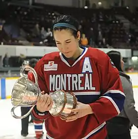 Photographie de Caroline Ouellette sous le maillot des Stars de Montréal tenant la Coupe Clarson