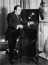 Caruso pose aux côtés d'un phonographe.