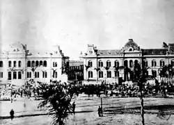 Les édifices du gouvernement (à gauche) et la poste (à droite) en 1890, avant leur réunion par l'architecte Tamburini qui en fait le palais actuel.