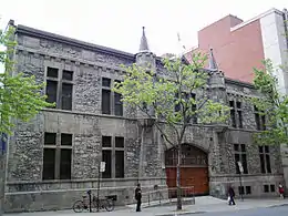 Photographie en couleur de la façade d'un bâtiment en pierre.