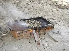 1. Les noix sont placées sur une tôle au-dessus d'un feu.
