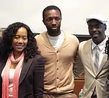 Photo de Sonja Sohn, Jamie Hector et Michal K. Williams regroupés devant un tableau d'université.